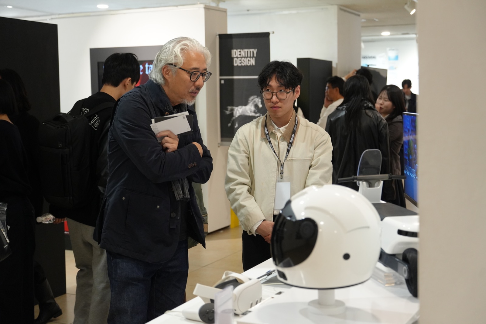 Jin discussing a project with a visitor at a design exhibition